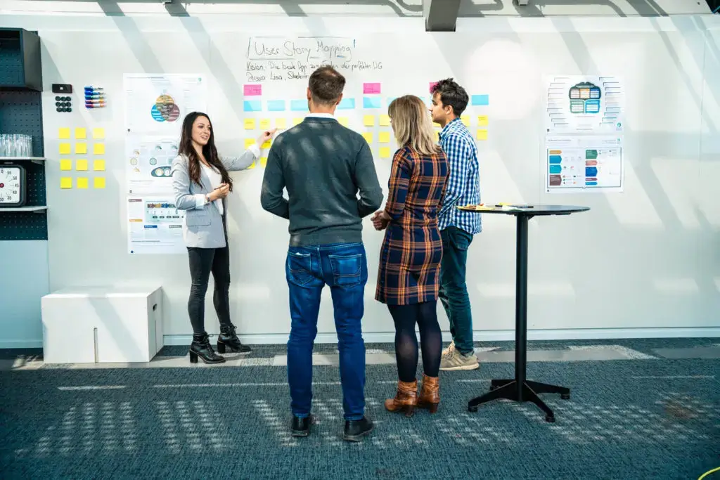 Teilnehmerinnen einer Produktmanagement Schulung diskutieren die Ergebnisse einer Praxisübung zum User Story Mapping